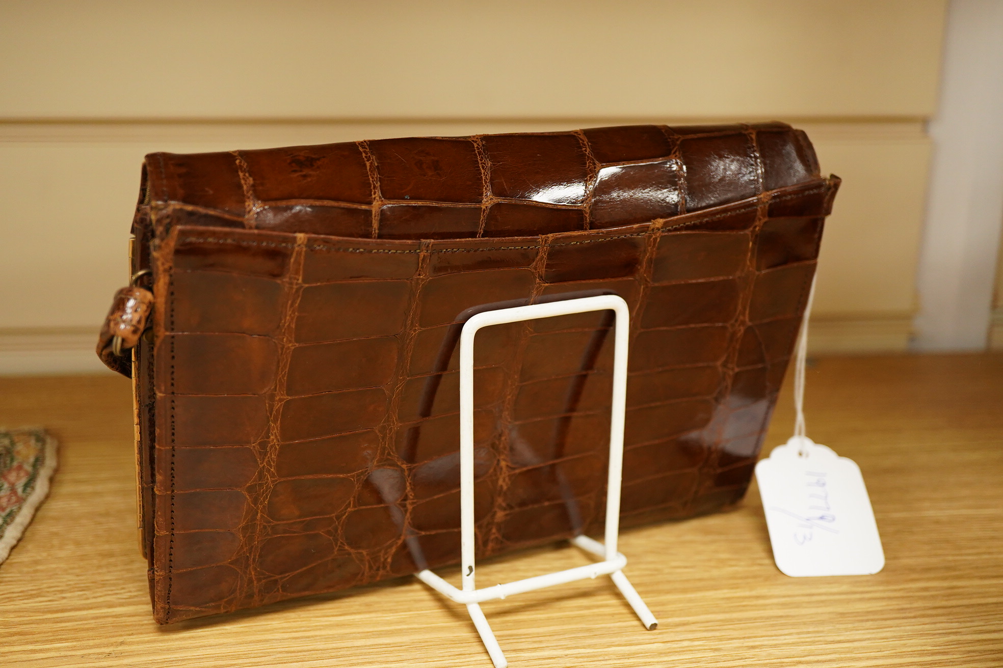A stylish 1930's ladies 9ct gold mounted brown crocodile handbag, fitted with small wallet and mirror, 21.5cm wide x 15cm high. Condition - the corners to base, top and handle have wear, the silk lining has a small split